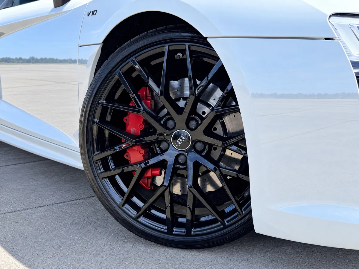 Gloss-black alloy wheel and red brake caliper on the Norwich Audi R8 hire car