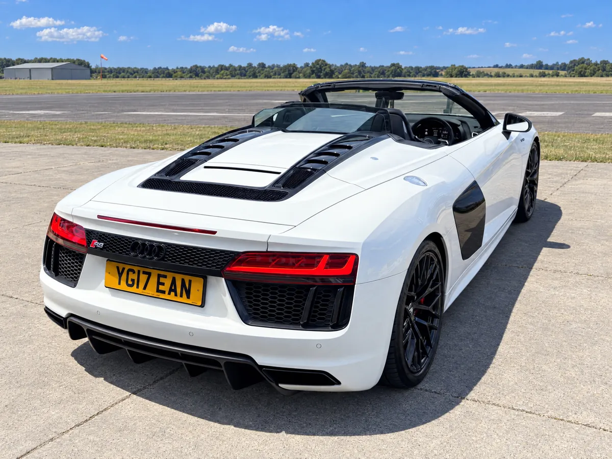High rear three-quarter of the white Audi R8 Spyder, roof down, hired for a celebration