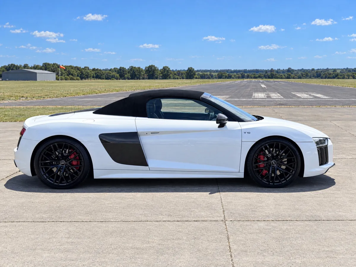 Side profile of the white Audi R8 Spyder hire car with gloss-black alloys